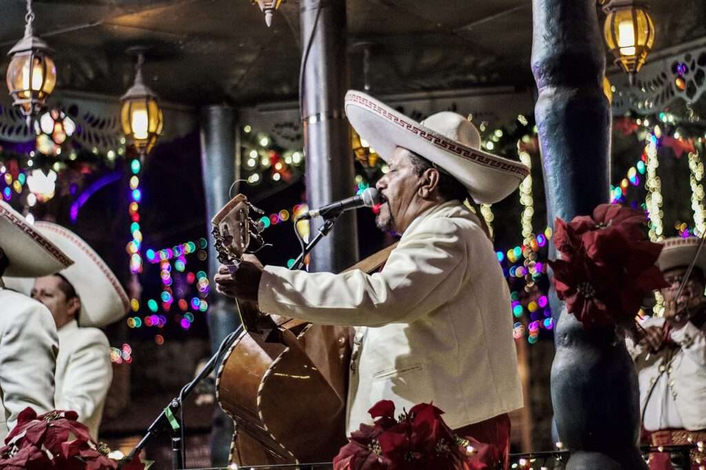 Un cantante de mariachi entona una canción y toca un instrumento musical, como parte de la música en vivo en una fiesta patronal. 