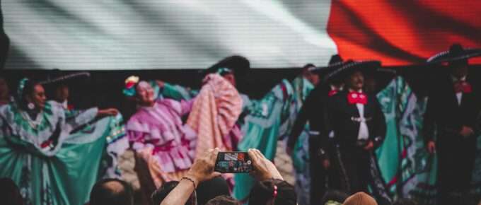 Vista desde el público de la presentación de un ballet folclórico, como parte de un evento de fiestas patrias en México.
