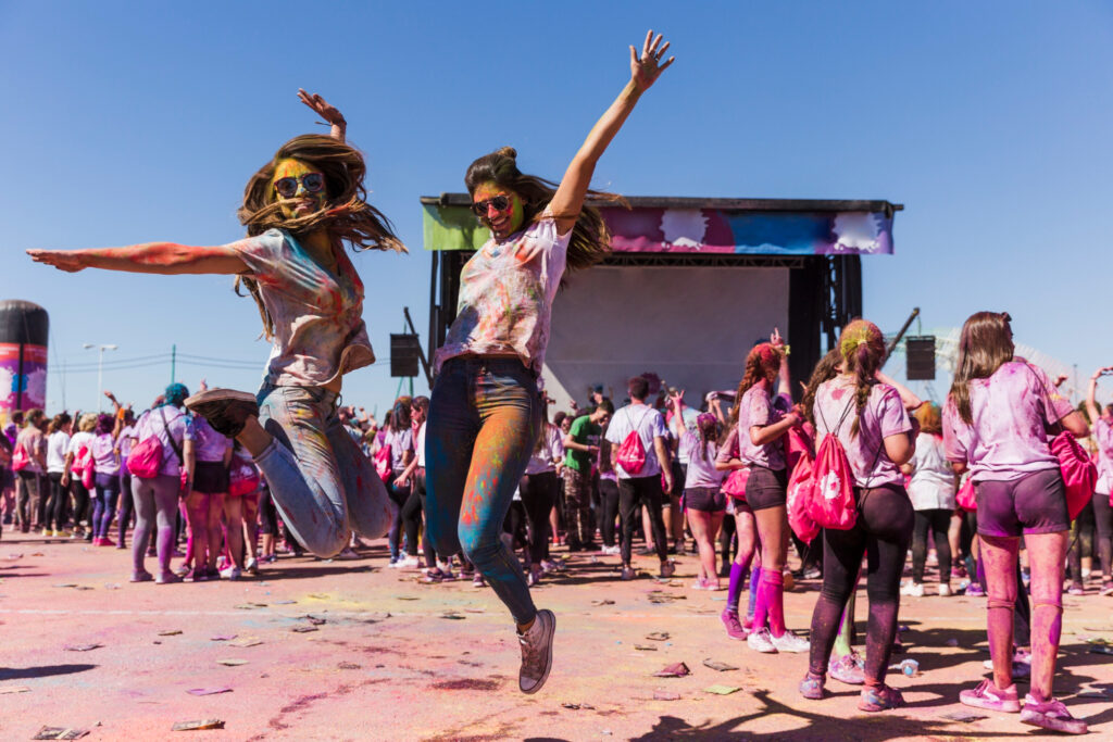 Mujeres jóvenes bailan durante su asistencia a un evento cultural juvenil masivo. 