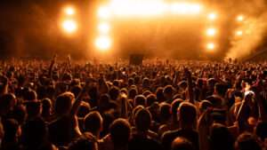Vista de una multitud ante un escenario, para ilustrar los tipos de evento y público que pueden determinar el elenco artístico.